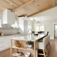 Thumbnail of http://Open%20concept%20kitchen%20with%20a%20large%20island%20in%20the%20center.%20On%20the%20left%20is%20a%20wall%20of%20cabinetry%20that%20includes%20the%20oven,%20stove,%20and%20fridge.%20In%20the%20center%20is%20a%20large%20island%20with%20open%20shelves%20on%20the%20end%20,%20the%20sink,%20and%20seating.