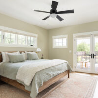 Thumbnail of http://Primary%20bedroom%20with%20multiple%20windows,%20including%20two%20doors%20out%20to%20the%20back%20deck.%20The%20room%20is%20furnished%20with%20a%20bed,%20rug,%20and%20two%20nightstands.