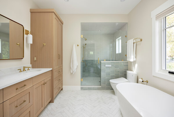 Primary bathroom with the sink and cabinetry on the left, shower straight ahead, and the toilet and tub on the right.