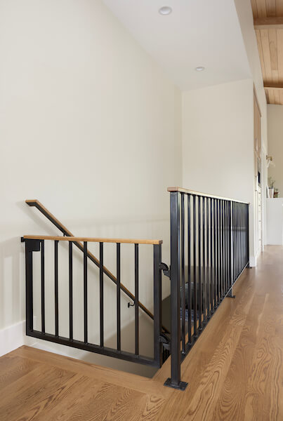 Custom built-in dog gate at the top of the stairs that matches with the railing.
