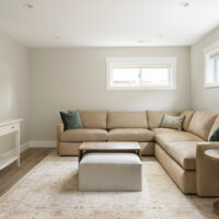 Thumbnail of http://Family%20room%20in%20the%20basement%20with%20an%20L-shaped%20couch%20underneath%20the%20windows%20and%20with%20a%20coffee%20table%20and%20TV%20in%20front.
