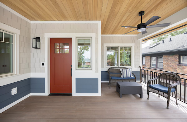 Covered front porch with a small sitting area to the right of the front door.