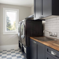 Thumbnail of http://Laundry%20room%20with%20the%20washer%20and%20dryer%20raised%20up%20on%20a%20cabinet%20and%20a%20sink%20adjacent.