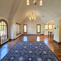 Thumbnail of http://Historic%20home%20great%20room%20remodel%20with%20vaulted%20ceilings,%20an%20open%20concept%20living%20room%20and%20dining%20room,%20and%20arch%20openings%20with%20access%20to%20the%20hallway%20and%20kitchen.%20In%20the%20living%20room%20a%20large%20area%20rug%20is%20placed%20on%20the%20floor.%20In%20the%20living%20room%20and%20dining%20room%20identical%20lights%20are%20hung%20from%20the%20vaulted%20ceiling.