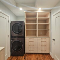 Thumbnail of http://Walk-through%20closet%20with%20hardwood%20floors,%20cabinets,%20and%20a%20stacked%20washer%20and%20dryer.